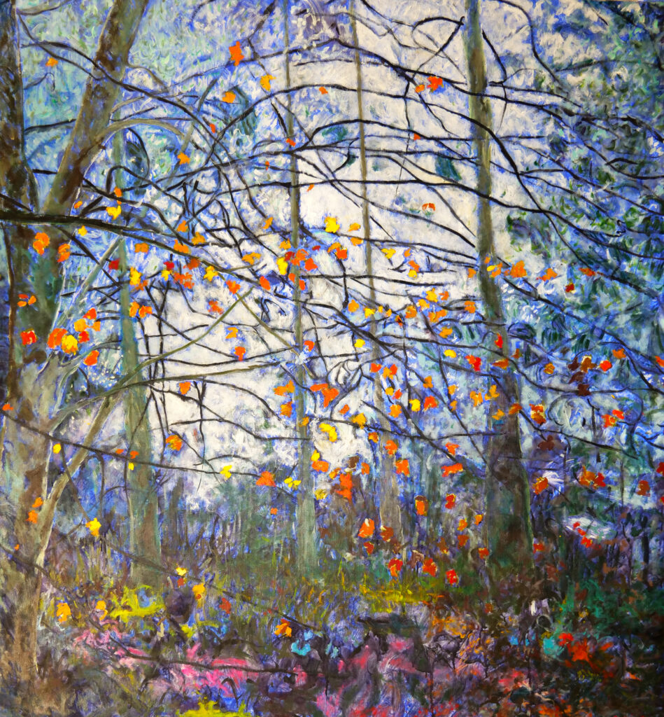 J "A l'orée du bois",Huile sur toile, 130 X 120 cm, 2025, Jean Louis Garcin. Dans une forêt d'un bleu évanescent une lumière tamisée, des arbres aux feuilles d'automne clairsemées, un sol aux couleurs contrastées. Noir, rouge, vert, violet, rose, jaune. Paysage, nature, forêt. Beauté, poésie.
À l'orée du bois, 2025
Jean-Louis Garcin
Huile sur toile, 130 × 120 cm
Un sous-bois en lisière — cet espace entre deux mondes, ni forêt fermée ni plein air. La lumière blanche irradie au centre, source diffuse qui traverse les troncs verticaux et le lacis de branches nues. Le fond est bleu-lavande, vaporeux, presque aquarellé.
Et sur ce fond froid — des feuilles orange et rouges, vives, précises, suspendues. Chacune est un point de chaleur dans la lumière froide. Elles ne tombent pas — elles flottent, tenues par le regard du peintre.
En bas, le sol se couvre de couleurs multiples — roses, jaunes, verts, bleus — foisonnement discret qui ancre la composition sans l'alourdir.

Ce qui frappe
La tension entre deux traitements. Les branches — graphiques, noires, linéaires, héritées de Lacis. Et les feuilles — taches chaudes, gestuelles, presque abstraites — qui les habitent sans les suivre.
C'est la toile la plus lumineuse et la plus apaisée de l'ensemble. Pas de dramatisme, pas de nuit. Juste cette lumière blanche d'entre-saison, ce moment où la forêt se dépouille et révèle sa structure.
L'orée comme état de conscience — ni dedans ni dehors, ni plein ni vide. Exactement là où JLG peint.
