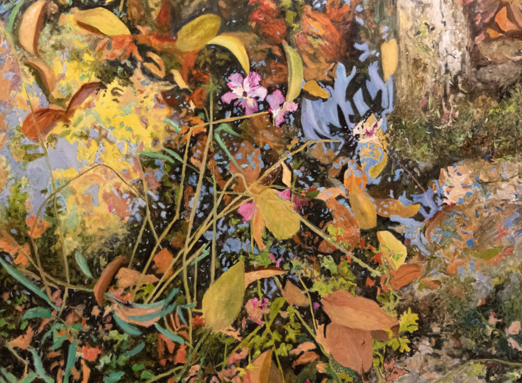 Un reflet de la lumière dans une flaque où se mêle feuillage, fleurs.